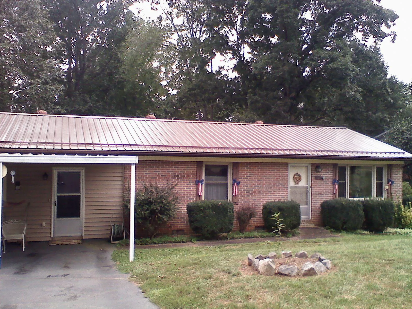 Bronze metal roof and carport on a brick ranch home — Roof Repair work by our crew in Modena